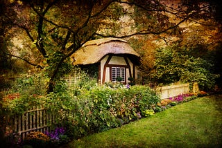 small country cottage surrounded by green plants and trees