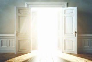 white doors open into a room filled with bright white light