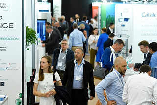 A photograph of visitors walking between stands at Connect In Pharma trade show