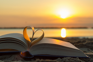 a book of poetry on a beach and a lovely sunset