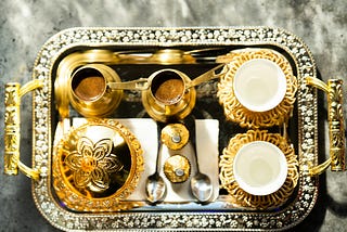 An ornate tray of gold and silver crockery to denote a luxurious life