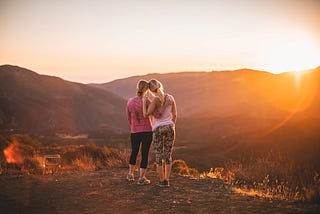 Two women hugging on a hike
