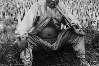 Wise Chinese farmer relaxing in the valley after a hard day’s work