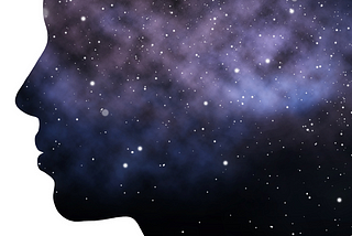 Profile of a woman’s face with a galaxy in her, stretching out behind her