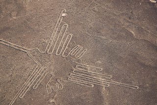 Aerial view of the Nazca lines seen from high above. Image of a bird in long lines marked out over a very large desert area.