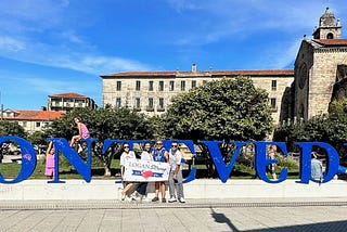 Lee Logan with his wife, son and daughter holding a “Logan Strong” banner in front of Pontevedra sign in Spain