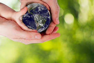 adult and child hands holding planet earth