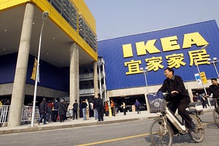 A man biking in front of a large IKEA store in Shanghai