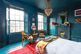 A wood-paneled bedroom painted in various shades of deep blue.