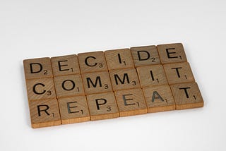 Scrabble letters that spell out “decide, commit, repeat” in that order.