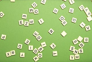 Scrabble letters thrown onto a mid-green background.