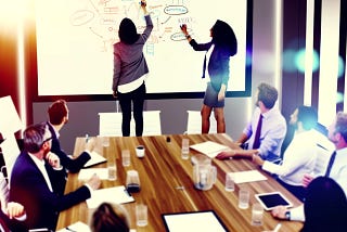 A dynamic and engaging conference room scene focused on collaboration and innovation through the use of whiteboards. The room is filled with a diverse group of professionals, actively participating in a brainstorming session.