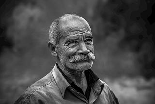 Older man with mustache smiling