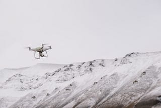 A drone flies above the arctic white mountains of Svalbard.