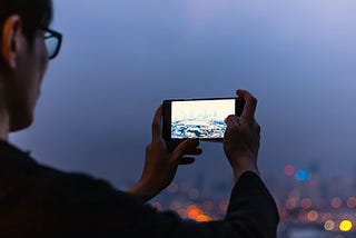 A tourist takes a vacation photo of a skyline.