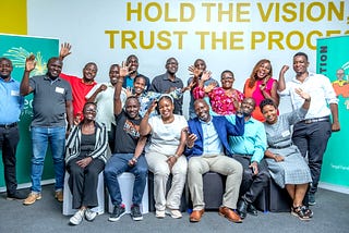A group of Ugandan adults pose happily for the camera