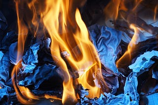 Fire beats paper in a burst of flames.