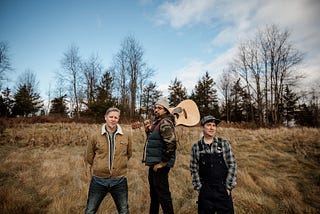 Ben, Paul (with guitar) and Mat in the field for the shoot for the song