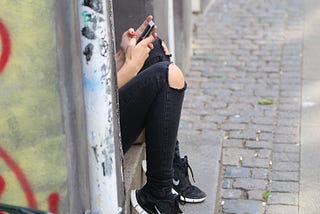 Imagem de uma mulher teclando no celular.