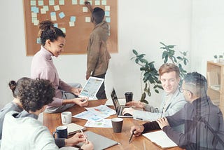 Group of People Sitting Indoors and Brainstorming