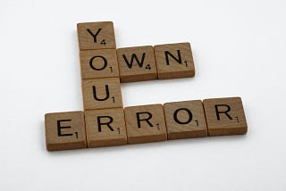 Wooden blocks that say “Own Your Error”