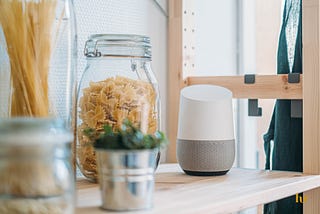 Google Home on a kitchen rack beside jars with pasta