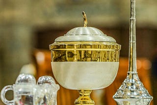 fancy communion cups on a church altar in gold, silver, and crystal