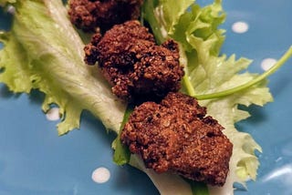 Photo by author. Three pieces of boneless fried chicken sit on a lettuce leaf on a blue plate.