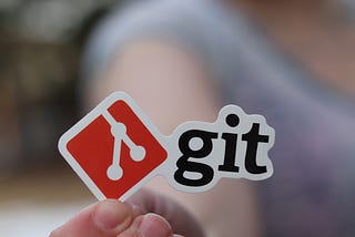 Fingers holding git sticker