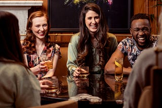 A photo of a group of young people sitting in a pub and drinking