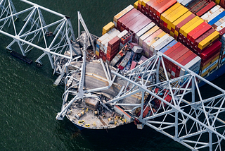 A huge container ship has hit the Francis Scott Key Bridge in Baltimore, MD. The ship is stuck under the bridge. Bridge collapse, history, Biden