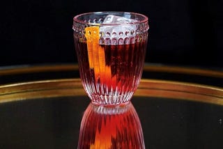 A Ruby Red Negroni Cocktail with an Orange Twist in an Elegant Crystal Glass