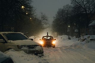 Car on highway in snow storm with lights