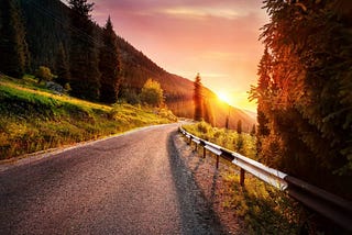 A scenic road going straight in sunrise colours