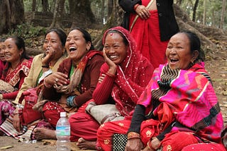 women in nepal dressed in pink and red laughing