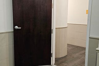 A tall automatically closing fire door propped open at an apartment