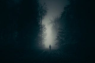 A image a person standing in a ghostly light on a dark night