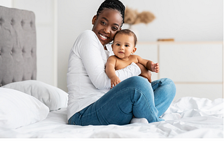 Getty Images. Photo showing cheerful black mother hugging her baby.