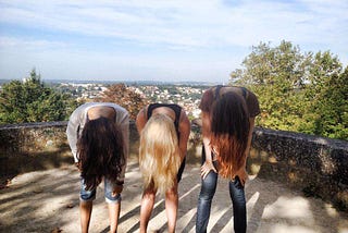Three women with their hair flipped over to cover their faces.