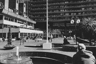 sitting on the lakeside terrace bench of the barbican