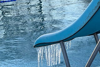 a view of parliament hill lido with icicles hanging from the slide