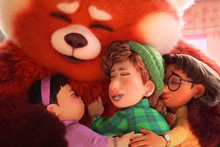 A frame from Turning Red where the main character as a giant red panda, Mei, hugs her three friends.