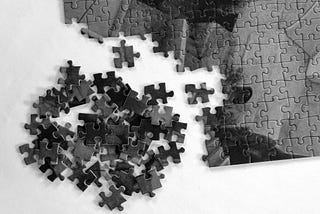Partially completed puzzle with scattered pieces on a white background, symbolizing a product being designed without a clear vision.