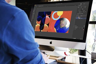 Graphic designer at work in the Amadine App on an iMac.