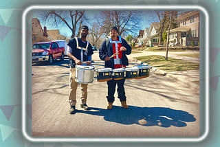2 men drumming on a city street
