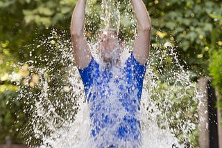 Young man pouring ice water bucket on his head.