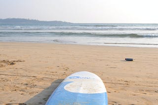 A surfboard on a sandy beach.