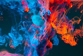 Blue, red and orange liquids merging over a black background