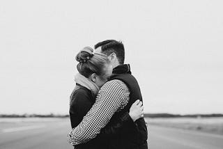 A black and white picture of a women and a man hugging