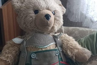 shows photo of champagne teddy bear wit a Bavarian Lederhosen und elegant red shoes! he is Hardy the teddy my parents used.
